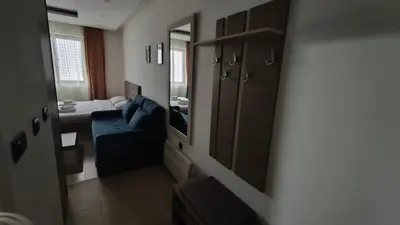 a living room with a blue couch and a mirror at Blistava Dolina S42 in Kopaonik