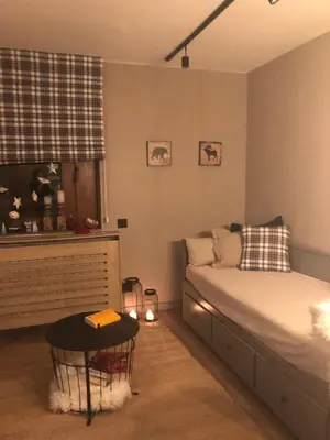 a bedroom with a bed and a table in it at Apartman Stemaks, Kopaonik in Kopaonik