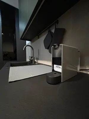 a kitchen counter with a sink and a microwave at Tokyo88 Apartment in Niš