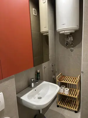 a bathroom with a sink and a mirror at Tokyo88 Apartment in Niš