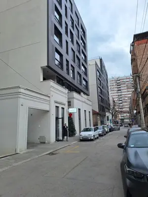 a street with cars parked on the side of a building at Tokyo88 Apartment in Niš