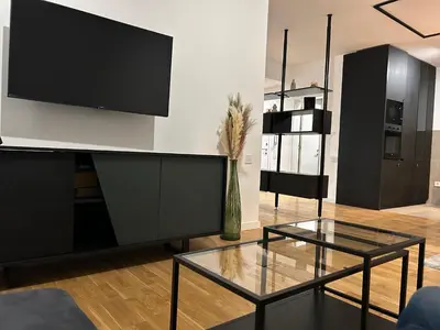 a living room with a tv and a glass table at Tokyo88 Apartment in Niš