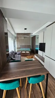 a dining room with a wooden table and green chairs at Apartman Vrabac in Vrnjačka Banja