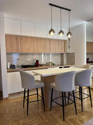 a kitchen with a table and chairs in a room at Apartman La Campanella 2 in Vrnjačka Banja