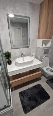 a bathroom with a sink and a toilet and a mirror at Apartman La Campanella 2 in Vrnjačka Banja