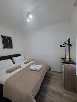 a bedroom with two beds and a cross on the wall at Apartman Akva Park in Trnava