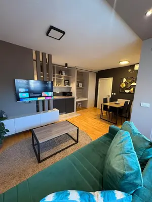 a living room with a green couch and a table at NAR Royalton Deluxe Apartment #74 Free Parking in Niš