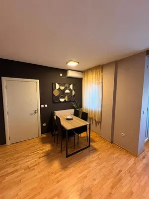 a dining room with a table and a table and chairs at NAR Royalton Deluxe Apartment #74 Free Parking in Niš