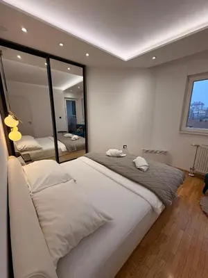 a bedroom with a large bed and a large mirror at NAR Royalton Apartment #25 Free Parking in Niš