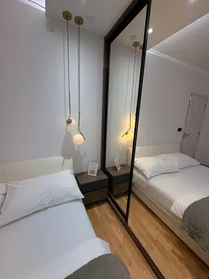 two beds in a room with a mirror at NAR Royalton Apartment #25 Free Parking in Niš