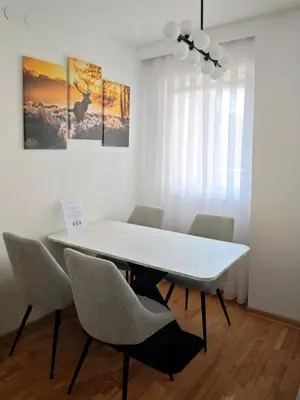 a white dining room with a white table and chairs at NAR Royalton Apartment #25 Free Parking in Niš