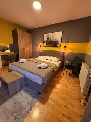 a bedroom with a bed and a table in it at NAR Royalton Apartment #76 Free Parking in Niš