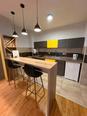 a kitchen with a wooden table and two chairs at NAR Royalton Apartment #76 Free Parking in Niš