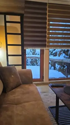 a living room with a couch in front of a window at Prime NG Mujen lux & spa in Cajetina