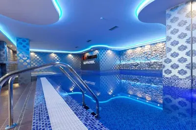 a swimming pool with blue lights in a building at Prime NG Mujen lux & spa in Cajetina