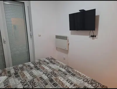a bedroom with a bed and a flat screen tv at Apartman Štekić in Vrnjačka Banja