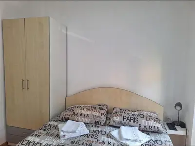 a bedroom with a bed with a wooden headboard and pillows at Apartman Štekić in Vrnjačka Banja