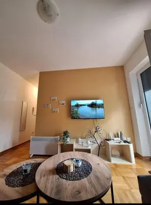 a living room with a wooden table and a couch at Apartman Štekić in Vrnjačka Banja