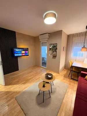 a living room with a red couch and a table at NAR Royalton Apartment #01 Free Parking in Niš