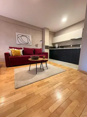 a living room with a red couch and a table at NAR Royalton Apartment #01 Free Parking in Niš