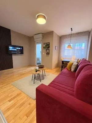 a living room with a red couch and a table at NAR Royalton Apartment #01 Free Parking in Niš