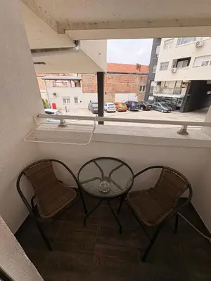 two chairs and a table on a balcony with a window at NAR Royalton Apartment #01 Free Parking in Niš