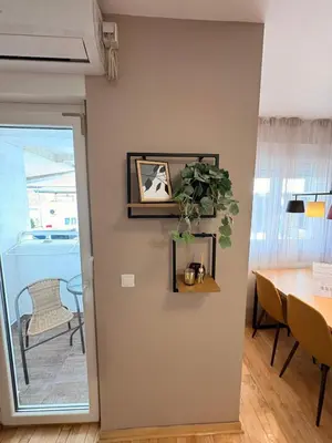 a dining room with a table and a plant on a wall at NAR Royalton Apartment #01 Free Parking in Niš