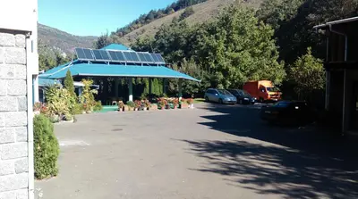 a parking lot with a building with a solar roof at Bed & Breakfast Karavan in Raška