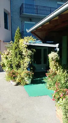 a green lawn in front of a building with flowers at Bed & Breakfast Karavan in Raška