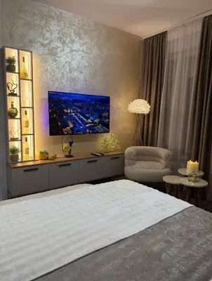 a bedroom with a bed and a tv on the wall at SpaNish FoROOM 1 in Niš