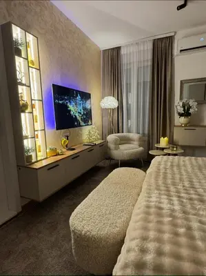 a large hotel room with a bed and a television at SpaNish FoROOM 1 in Niš