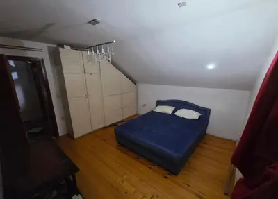 a bedroom with a blue bed in a attic at Kuća Petrovic in Niška Banja