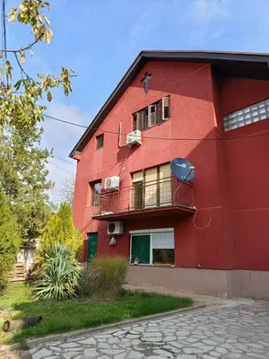 a red building with a balcony on the side of it at Kuća Petrovic in Niška Banja