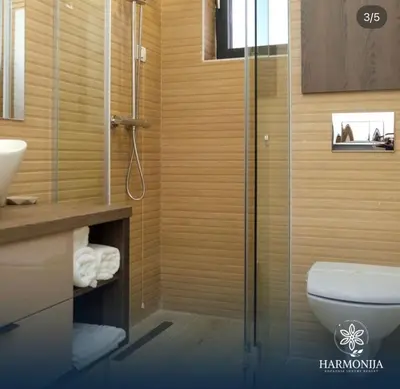 a bathroom with a toilet and a glass shower at DZAT apartman, Harmonija Hotel in Kopaonik