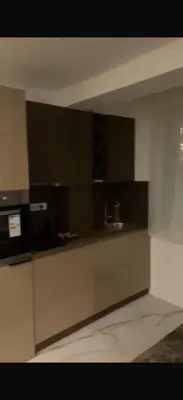 a kitchen with black cabinets and a counter top at DZAT apartman, Harmonija Hotel in Kopaonik