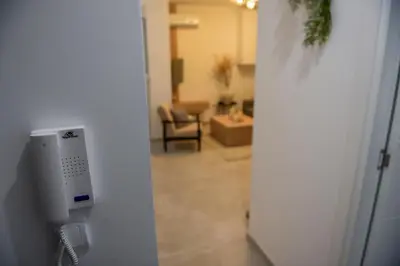 a door with a phone on a wall with a living room at Apartman P Lux 1 Ćuprija in Ćuprija