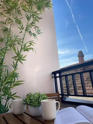 a table with two cups and a book on a balcony at Apartman P Lux 1 Ćuprija in Ćuprija