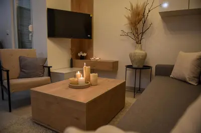 a living room with a couch and a coffee table with candles at Apartman P Lux 1 Ćuprija in Ćuprija