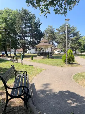 a park bench and a gazebo in a park at Apartman P Lux 1 Ćuprija in Ćuprija