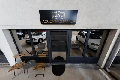 a view of a car dealership with chairs and a sign at NAR Royalton Deluxe Apartment #40 Free Parking in Niš