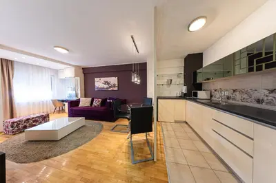 a kitchen and a living room with a couch at NAR Royalton Deluxe Apartment #40 Free Parking in Niš