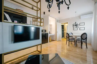 a living room with a large television and a table at NAR Royalton Deluxe Apartment #63 Free Parking in Niš