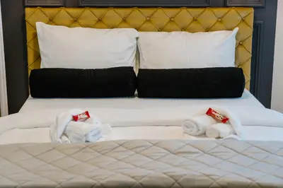 a bed with towels and pillows on it at NAR Royalton Deluxe Apartment #63 Free Parking in Niš