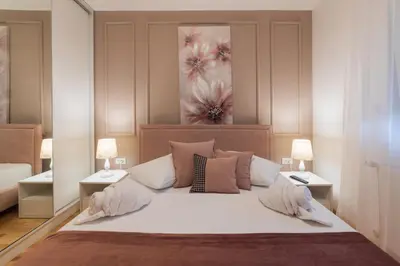 a bedroom with a large white bed with two lamps at NAR Royalton Apartment #71 Free Parking in Niš