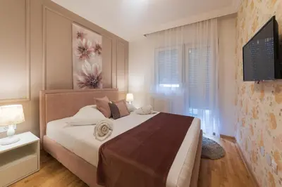 a bedroom with a large bed and a tv at NAR Royalton Apartment #71 Free Parking in Niš
