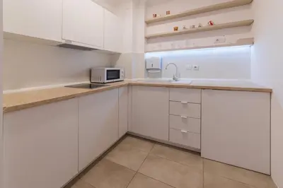 a kitchen with white cabinets and a microwave at NAR Royalton Apartment #71 Free Parking in Niš