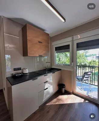 a kitchen with white cabinets and a balcony at Konačište u carstvu in Vrnjci