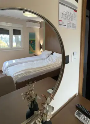 a bedroom with a bed and a mirror on a table at Konačište u carstvu in Vrnjci