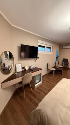 a bedroom with a desk and a large mirror at Konačište u carstvu in Vrnjci