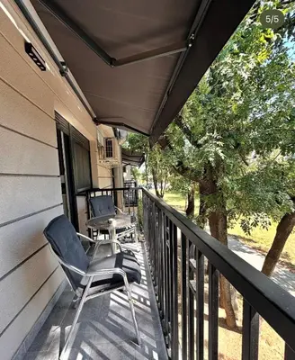 a porch with two chairs and a table on it at Konačište u carstvu in Vrnjci